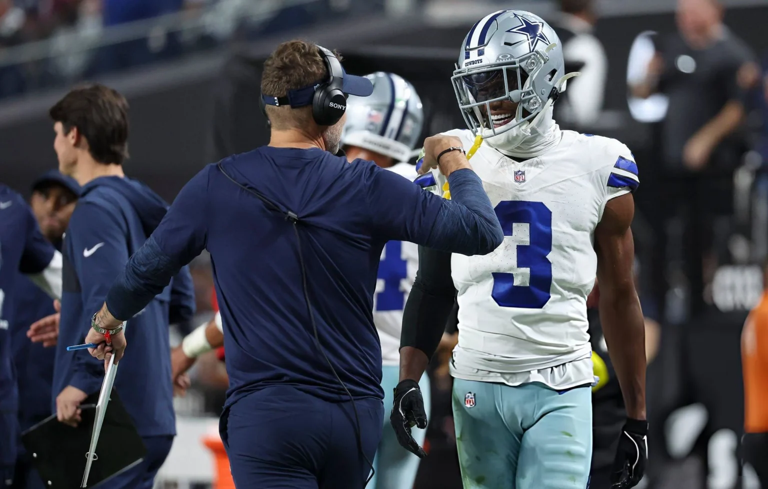 Brian Schottenheimer and George Pickens #3 of the Dallas Cowboys celebrate after their team's touchdown against the Las Vegas Raiders in the third quarter of a game at Allegiant Stadium